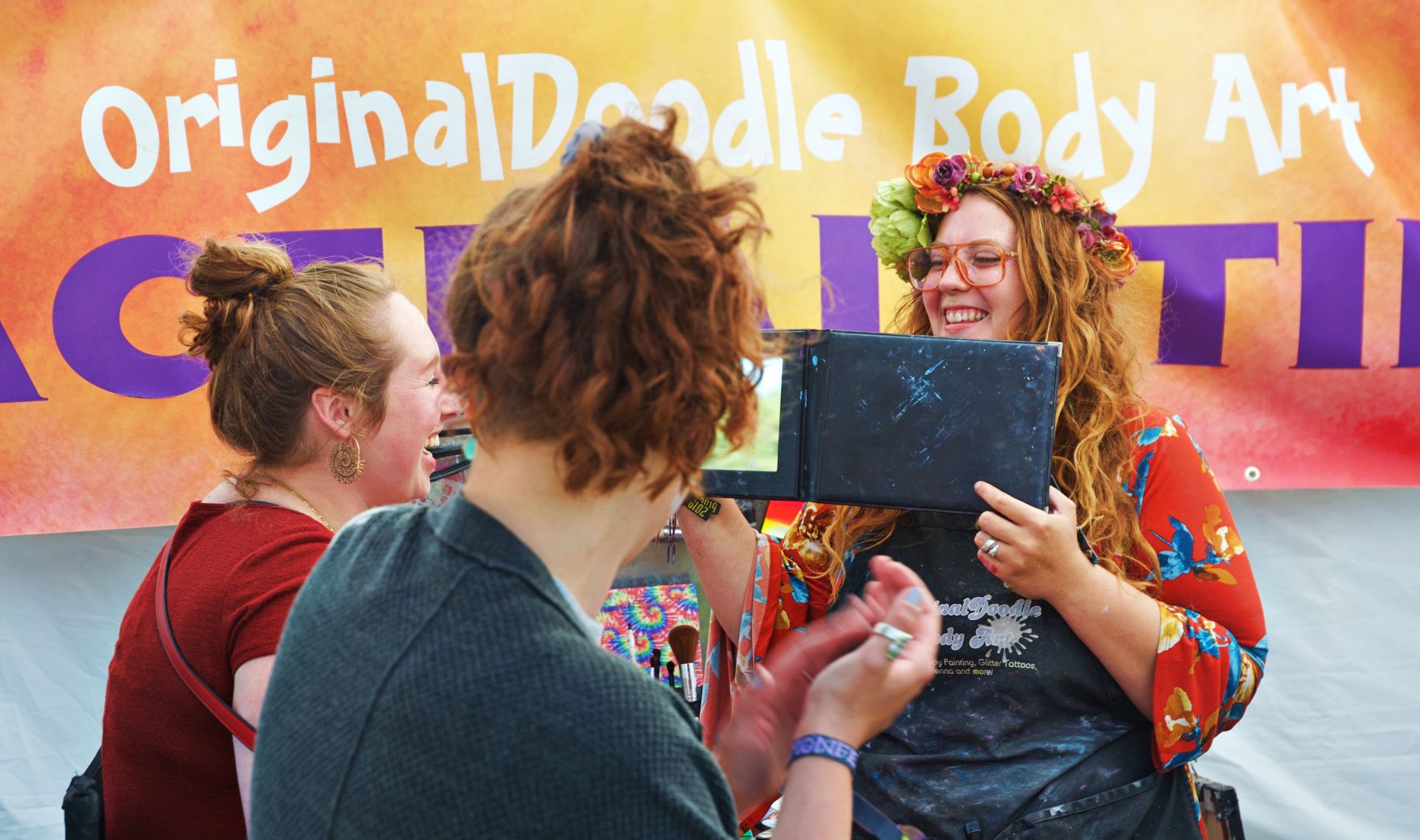 There were lines all weekend for glitter & paint from Lindsey at Original Doodle Body Art.jpg